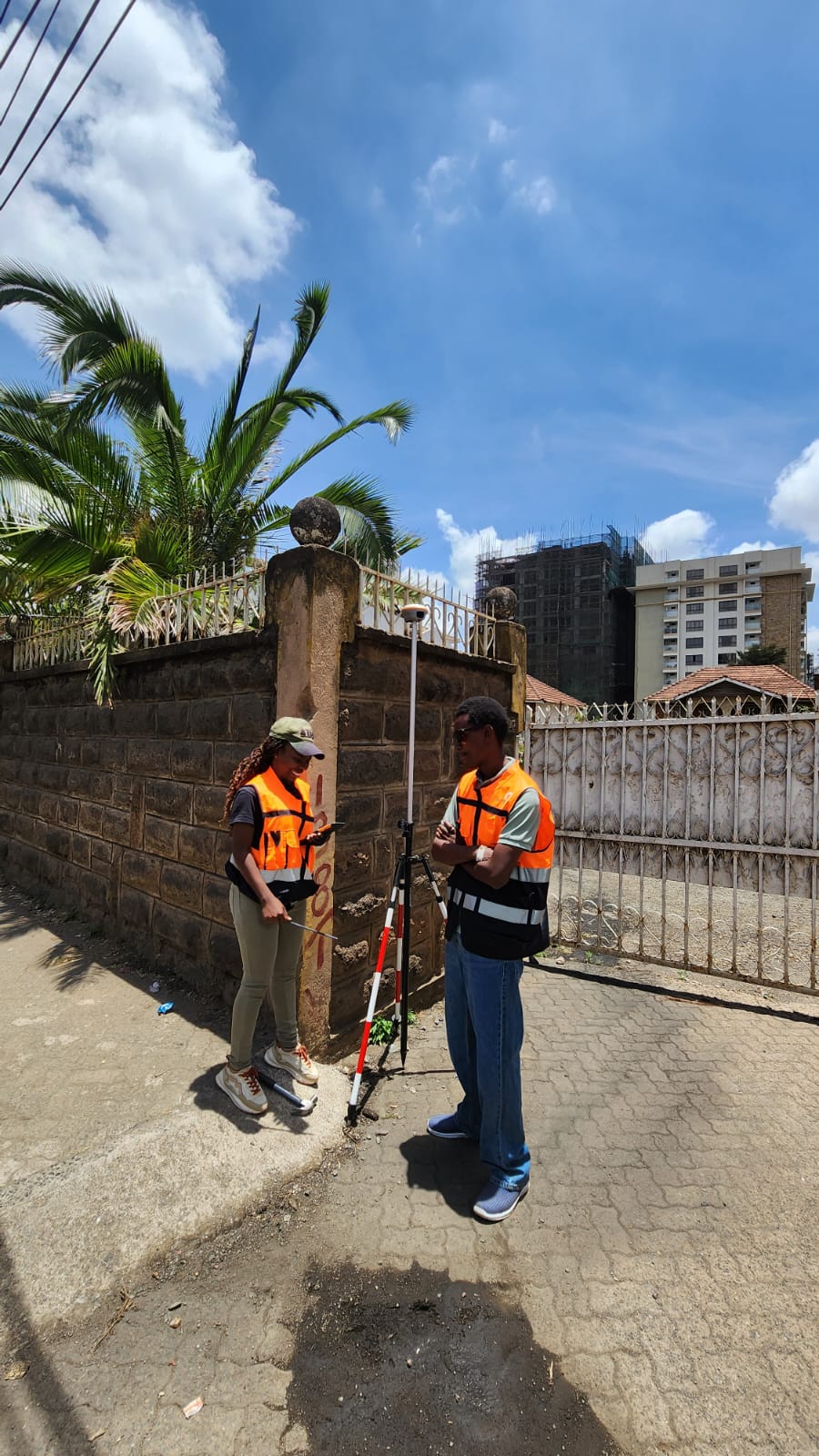 Surveyors establishing ground control beside an urban property in Nairobi